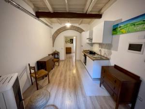 a kitchen with white walls and a wooden floor at Sh Suite Borgo in Bracciano