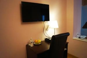 a room with a desk with a chair and a television on the wall at EU Guesthouse in Brussels