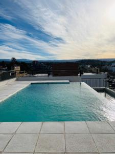 a swimming pool on the roof of a building at Depto "Ideal" Céntrico, Pile Climat y Pile en Terraza, Cochera, Calef Central in Villa Carlos Paz