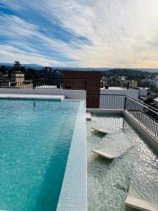 ein Schwimmbad auf dem Dach eines Gebäudes in der Unterkunft Depto "Ideal" Céntrico, Pile Int y Pile en Terraza, Cochera, Aire Ac in Villa Carlos Paz