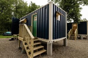 a tiny house with stairs and a green door at Schuyler Yacht Basin in Schuylerville +1 photo