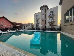 a swimming pool with a blue raft in the middle of a building at Pensiunea Tulip in Baile Felix