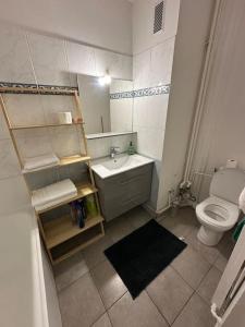 a small bathroom with a toilet and a sink at Appartement aux portes de Paris in Villejuif
