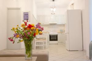a vase of flowers sitting on a table in a kitchen at ELIZABETH by Antigone in Halikounas
