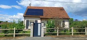 a small house with a roof with solar panels on it at Chambre à louer in Bonnétable