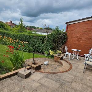 eine Terrasse mit 2 Stühlen, einem Tisch, einem Tisch und Stühlen in der Unterkunft Clifton House, For Holidays, Contractors, Relocation, Work, Etc, Free Parking and Wifi in Preston