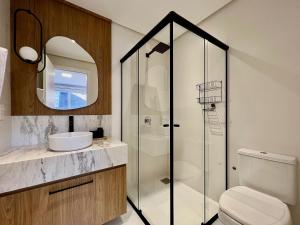 a bathroom with a shower and a toilet and a sink at Incrível Loft 235 1 Suíte Centro by Achei in Canela +47 photos