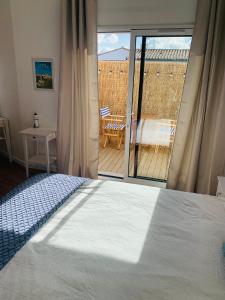 una camera da letto con un letto e vista su un balcone di Charmante maisonnette neuve proche Thalasso a Sainte-Marie-de-Ré