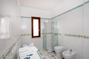 un bagno bianco con doccia e WC di Casa Ketty ad Amalfi Altre 7 foto