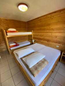 a bedroom with two bunk beds in a wooden wall at Residence Alberghiero Splendor in Folgarida