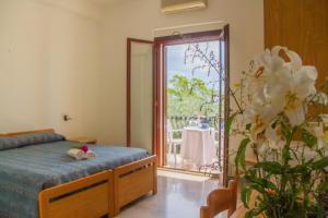 una camera da letto con un letto e un balcone con un tavolo di La Rotonda a Mattinata Altre 37 foto