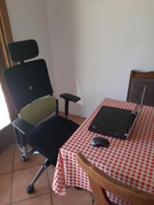 a desk with a chair and a laptop on a table at Holiday Home Bojko in Krapje