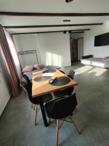 a room with a wooden table and black chairs at Apartamenty u Anety in Wilkasy