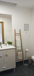 a bathroom with a towel rack next to a sink at Zambujeiraseahouse - 100m da praia in Zambujeira do Mar