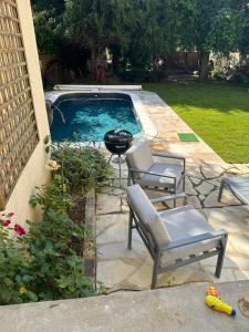 a backyard with a pool with chairs and a grill at Bonheur en Seine, Piscine, Vue Seine in Poissy