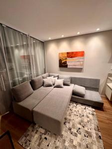 a large couch in a living room with a painting at Sensacional Flat Serra Class - vista do Pôr do Sol in Canela +12 photos