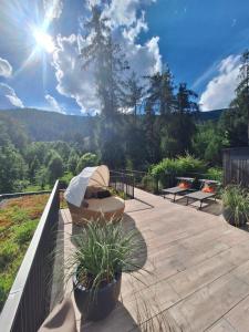 eine Terrasse mit Bänken und einem Sonnenschirm. in der Unterkunft Steindls Boutique Favourite in Sterzing