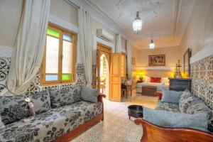 un soggiorno con un divano e un tavolo di Riad Inaka a Marrakech