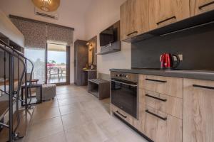 a kitchen with wooden cabinets and a stove top oven at Chasapis Luxury Apartments&Studios in Vourvourou
