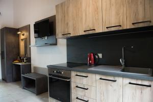 a kitchen with black counter tops and wooden cabinets at Chasapis Luxury Apartments&Studios in Vourvourou +2 photos