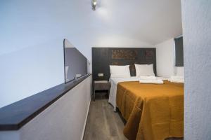 a hotel room with two beds with orange sheets at Chasapis Luxury Apartments&Studios in Vourvourou