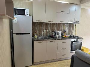 a kitchen with a white refrigerator and a sink at Sayat-Nova Apartments Yerevan in Yerevan