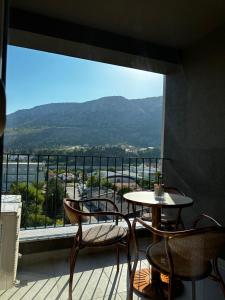 a balcony with a table and chairs and a large window at Apartment Ivan in Mostar