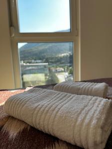 two towels sitting on a table in front of a window at Apartment Ivan in Mostar