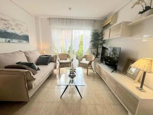a living room with a couch and a tv at El balcón de Alexia, 5 minutos del aeropuerto in Partida de La Cañada