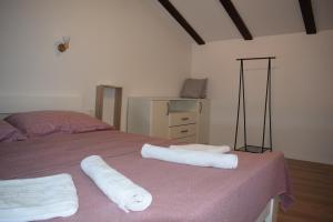 a bedroom with a bed with two towels on it at Apartments Kamelija in Punat