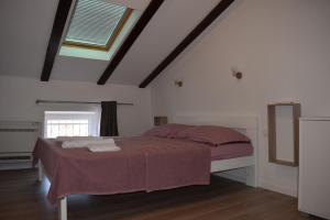 a bedroom with a large bed in a attic at Apartments Kamelija in Punat