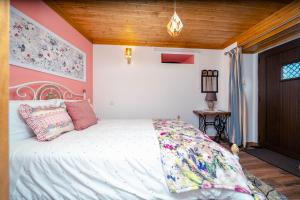 a bedroom with a white bed and a wooden ceiling at Montanhas do Xisto - Solar do Xisto Nascente in Candal
