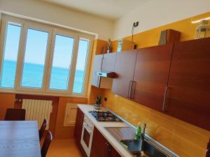 a kitchen with wooden cabinets and a counter top at Seafront Holidays & Workstays - Mare & Sole Apartments in Molfetta