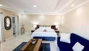 SandtonWaterfall City Guest Lodge的一间卧室，有一张床和一张蓝色沙发