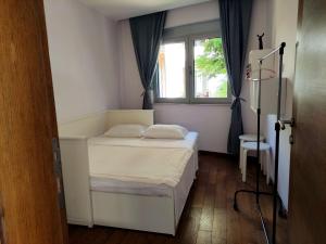 a small bedroom with a bed and a window at Nature Escape Amazing Sea View in Budva