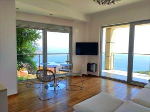 a living room with a table and a view of the ocean at Nature Escape Amazing Sea View in Budva