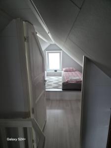 Zimmer im Dachgeschoss mit einem Bett und einem Fenster in der Unterkunft APARTAMENT - Duże mieszkanie w centrum Ålesund in Ålesund
