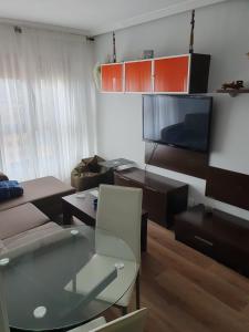 a living room with a couch and a flat screen tv at VISTAS MONTE NARANCO Apartamento CON PARKING 5euros al dia in Oviedo +29 photos