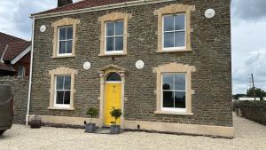 a yellow door on a brick house with a yellow door at The Old School House in Bristol