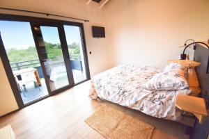 a bedroom with a bed and a sliding glass door at Magnifique duplex vue montagnes LARUN in Zugarramurdi +1 photo