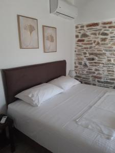 una cama en una habitación con una pared de ladrillo en Studios Aspasia, en Lavkos