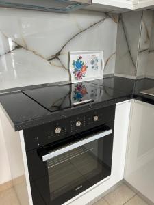 a black and white stove in a kitchen at Ameti - Ground Floor Comfort Suites - Spacious & Modern in Orikum