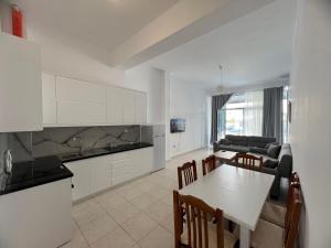 a kitchen and living room with a table and chairs at Ameti - Ground Floor Comfort Suites - Spacious & Modern in Orikum +49 photos