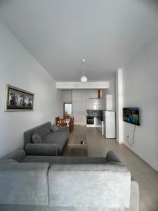 a living room with a couch and a kitchen at Ameti - Ground Floor Comfort Suites - Spacious & Modern in Orikum