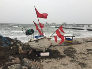 a boat on the beach with flags on it at Haus Strandläufer Wohnung 3 in Kellenhusen