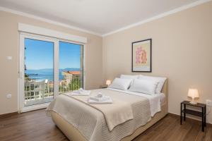 コストレナにあるSeaview Garden Premium apartmentsの大きなベッドと大きな窓のある寝室