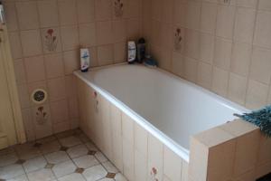 un bagno con una vasca da bagno con due bottiglie di shampoo di SALAMANDRES a Tergnier