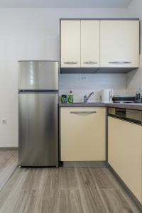 a kitchen with a stainless steel refrigerator and white cabinets at Lusi in Otočac +25 photos