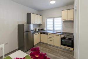 a kitchen with a stainless steel refrigerator and white cabinets at Lusi in Otočac