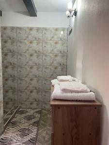 a bathroom with a shower with white towels on a counter at Casa Roșca in Tomşani +88 photos